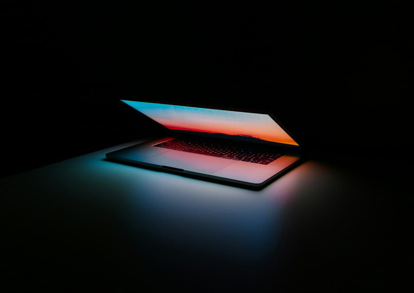 Ordinateur portable ouvert dans le noir, éclairé par son écran